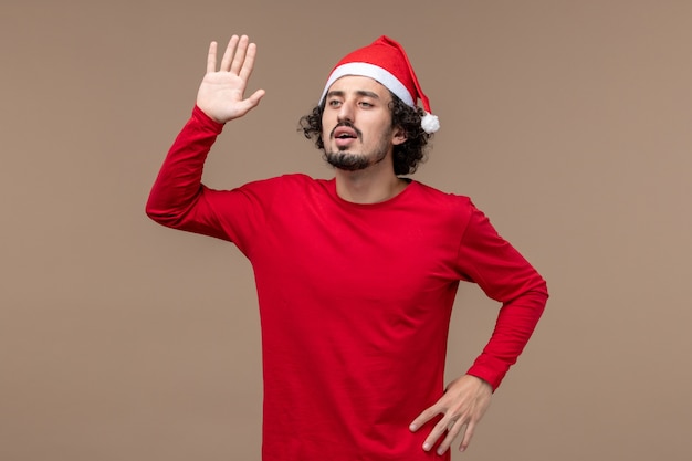 Get Festive with a Front View of a Young Man Waving on a Brown Background