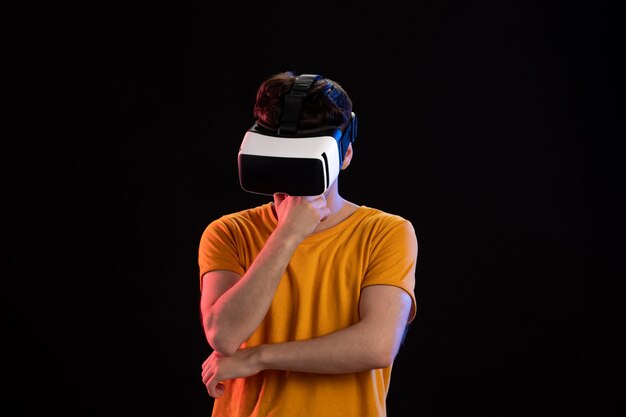 暗い壁に vr ヘッドセットを着ている若い男の正面図