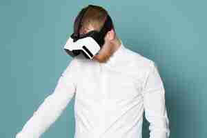 Free photo a front view young man in white shirt playing vr on the blue space