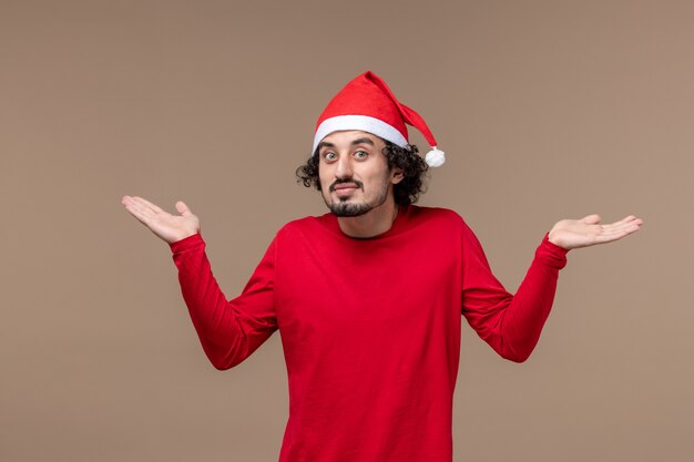 Front view young man with calm expression on brown background christmas emotion holiday