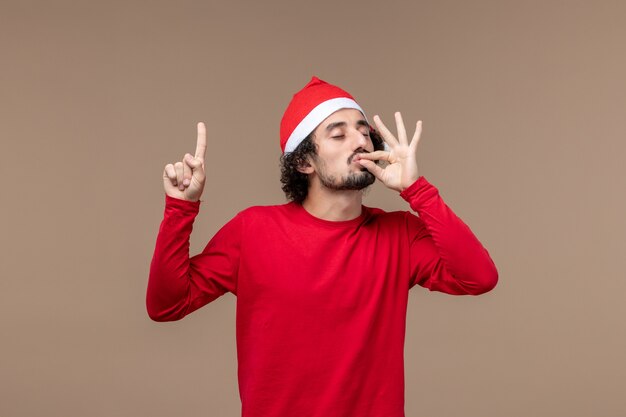 Front view young man with christmas cape on brown background emotion holiday christmas