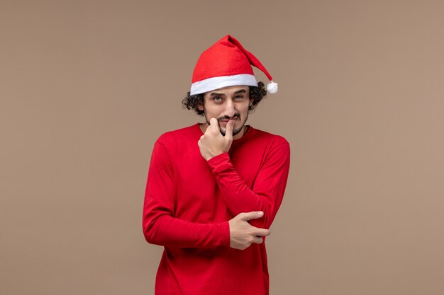 茶色の背景に混乱した表情の正面図若い男クリスマス感情休日