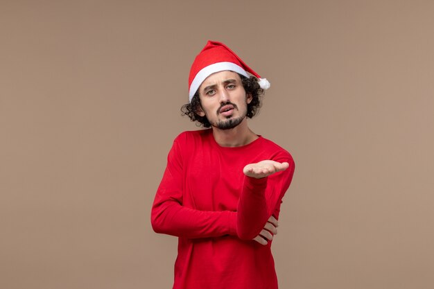 Front view young man with confused face on brown background holiday emotion christmas