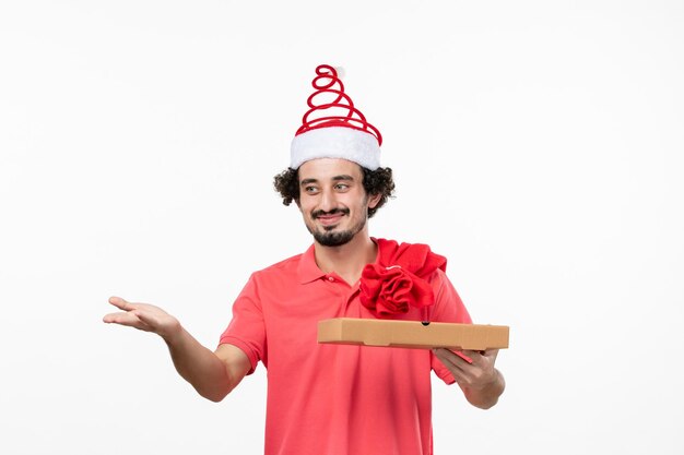 Front view of young man with delivery food box on the white wall