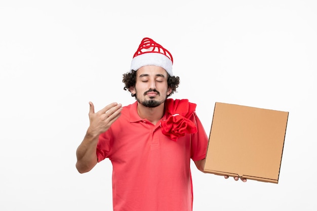 Front view of young man with delivery food box on white wall