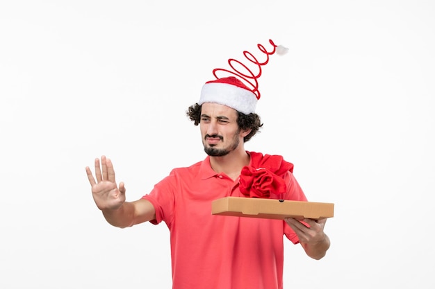 Front view of young man with delivery food box on white wall