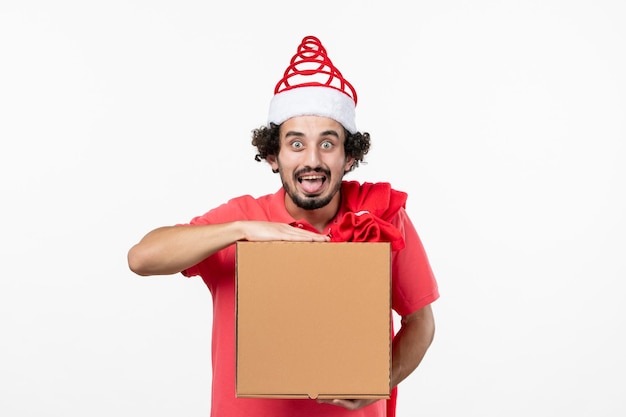 Front view of young man with delivery food box on white wall