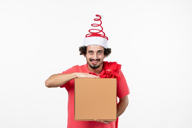 Front view of young man with delivery food box on white wall