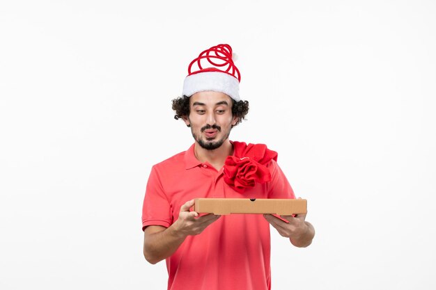 Front view of young man with delivery food box on white wall