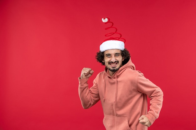 Front view of young man with excited expression on light red wall