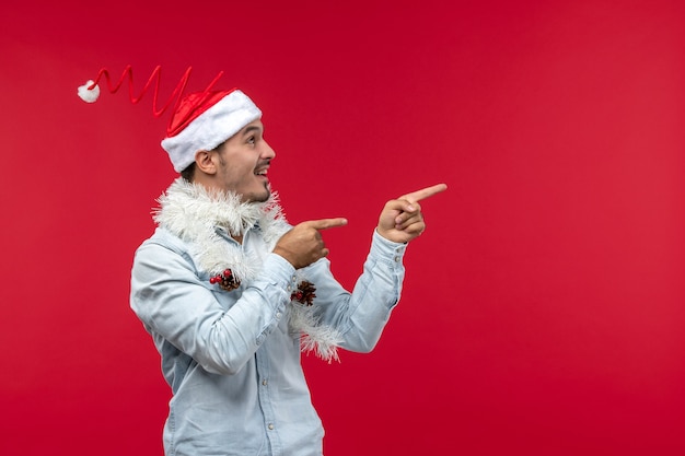 Front view of young man with excited expression on red wall