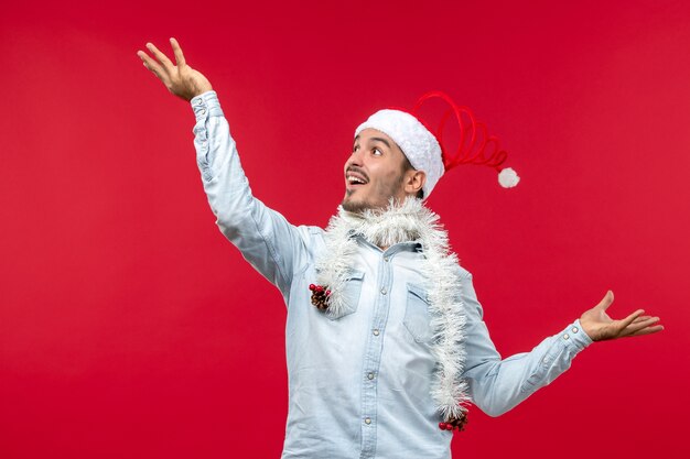 Front view of young man with excited expression on red wall