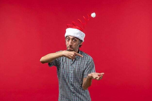 Front view of young man with excited expression on a red wall