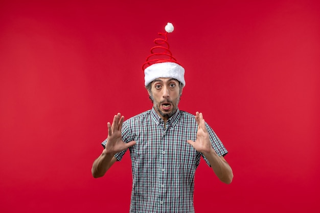 Front view of young man with excited expression on a red wall