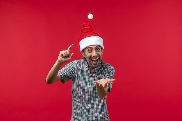 Front view of young man with excited expression on a red wall