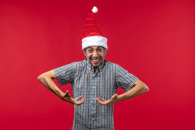 Front view of young man with excited expression on red wall