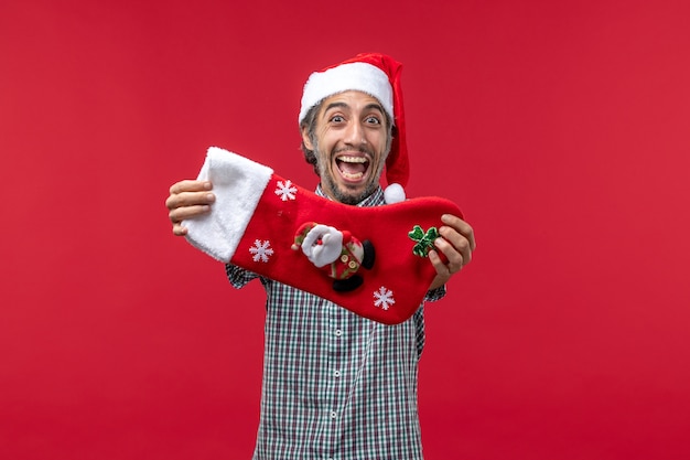 Front view of young man with excited expression on red wall