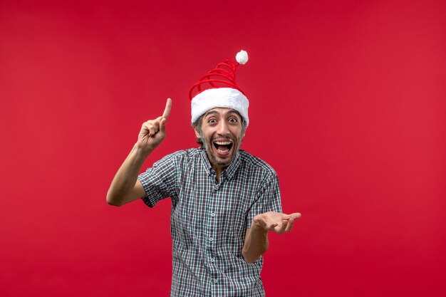 Front view of young man with excited expression on red wall