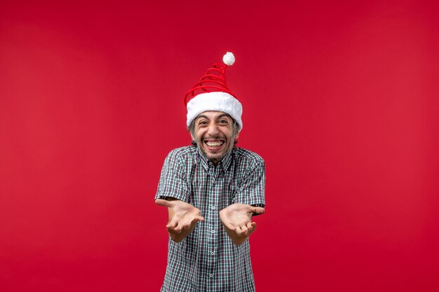 Front view of young man with excited expression on red wall