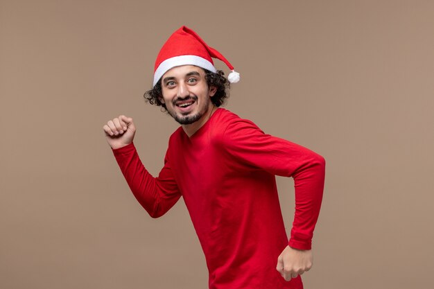 茶色の背景に興奮した顔の正面図若い男クリスマス感情休日