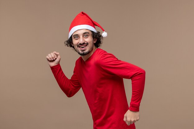 Front view young man with excited face on brown background christmas emotion holiday