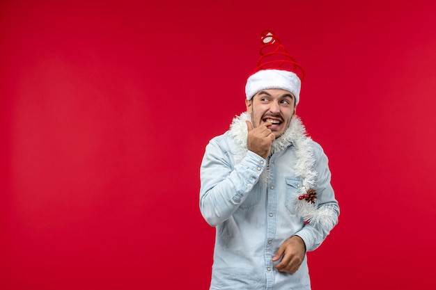 Front view of young man with nervous expression on a red wall