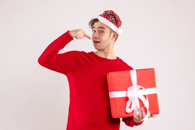 Front view young man with santa hat holding gift on white background