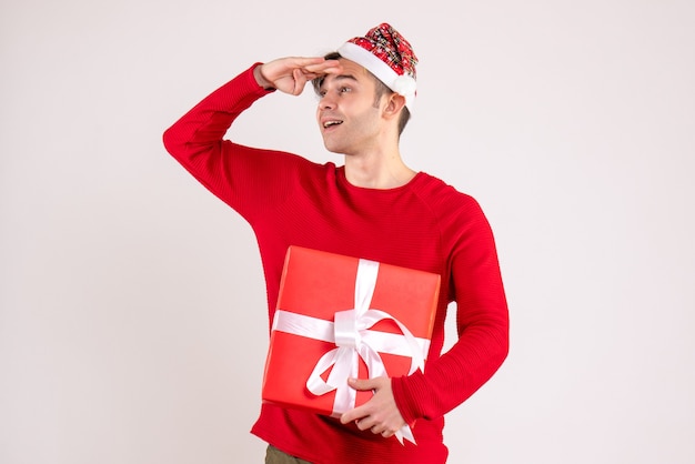 Front view young man with santa hat looking at something on white background