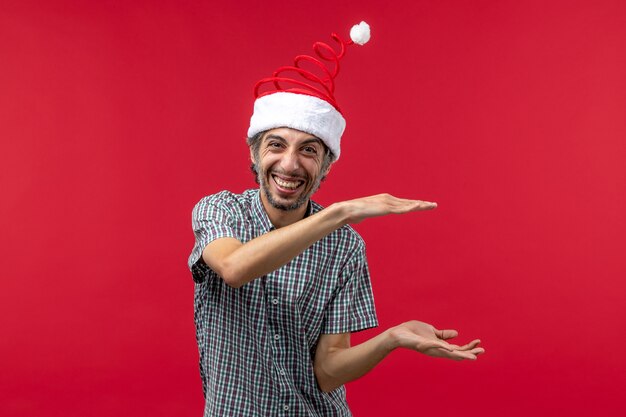 Front view of young man with smiling expression on red wall