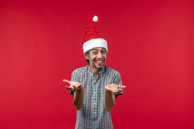 Front view of young man with smiling expression on red wall