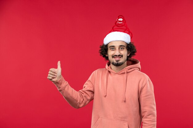 Front view of young man with smiling expression on red wall