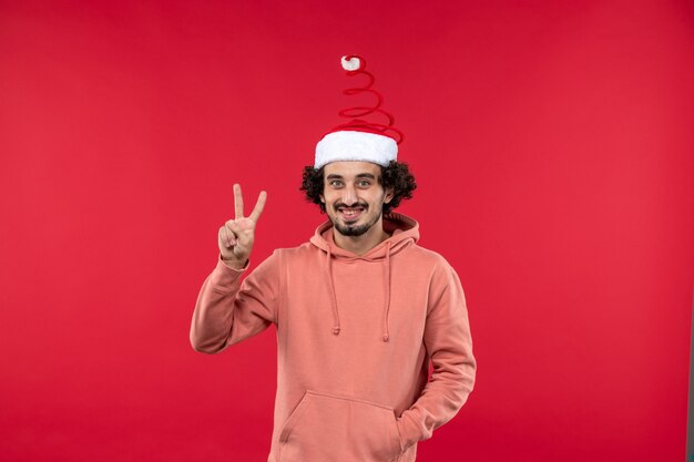 Front view of young man with smiling expression on red wall