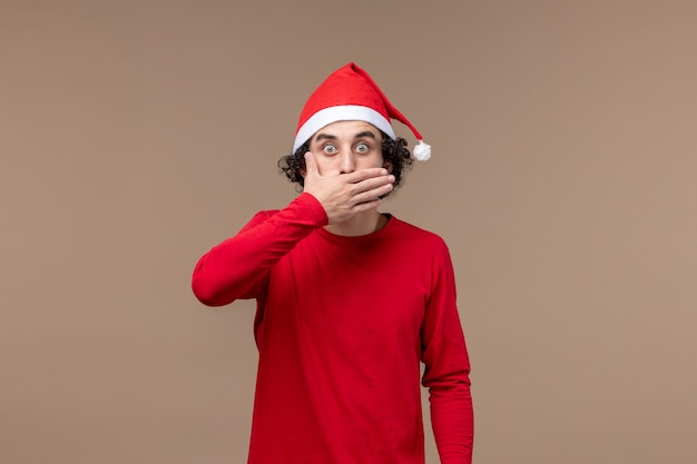 Free photo front view young man with surprised face on brown background christmas emotion holiday