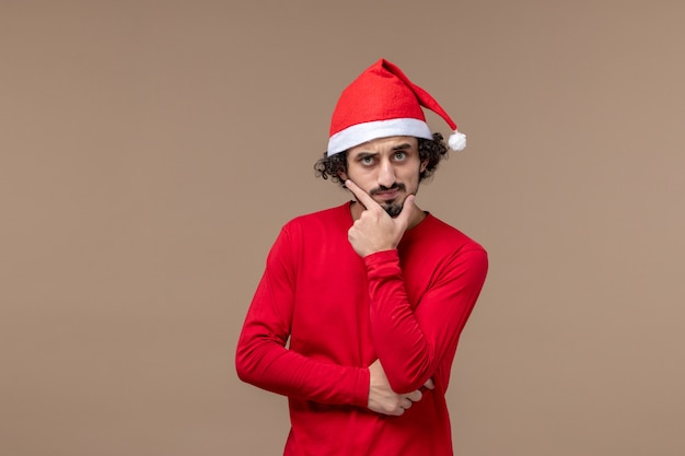 Front view young man with thinking expression on brown background christmas emotion holiday