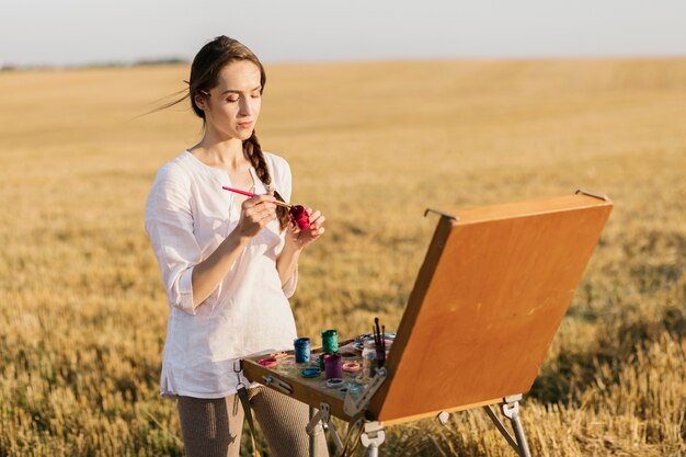 Front view young painter in the nature