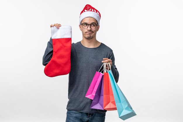 Front view of young person after holiday shopping on white wall