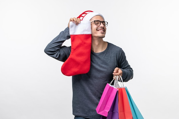 Front view of young person after holiday shopping on white wall