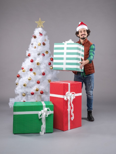 Front view young person around holiday presents on grey 