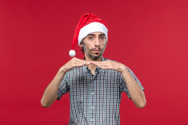 Front view young person with new year cap on red wall new year red holidays male