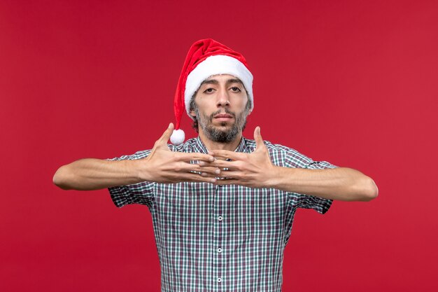 Front view young person with new year cap on red wall red new year holiday male