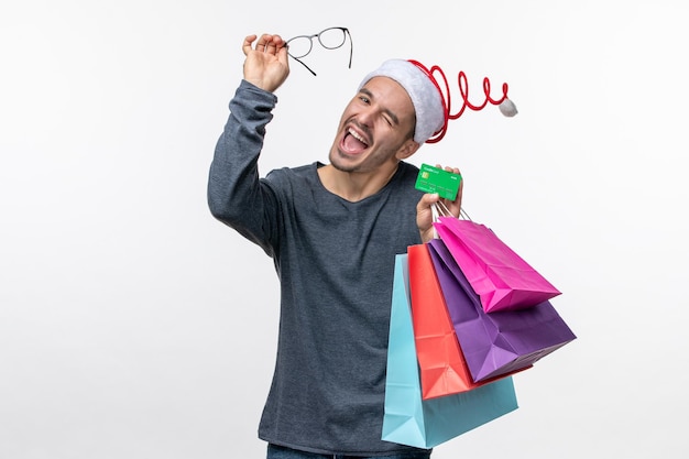 Front view of young person with packages on white wall