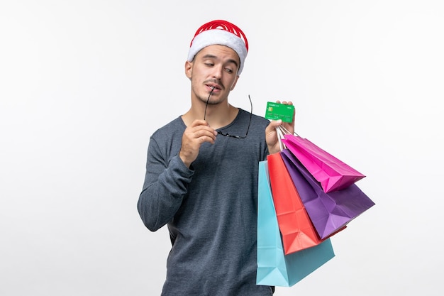 Front view of young person with packages on white wall