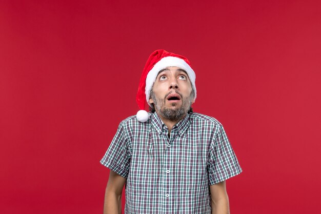 Front view young person with scared expression on red wall holiday new year red