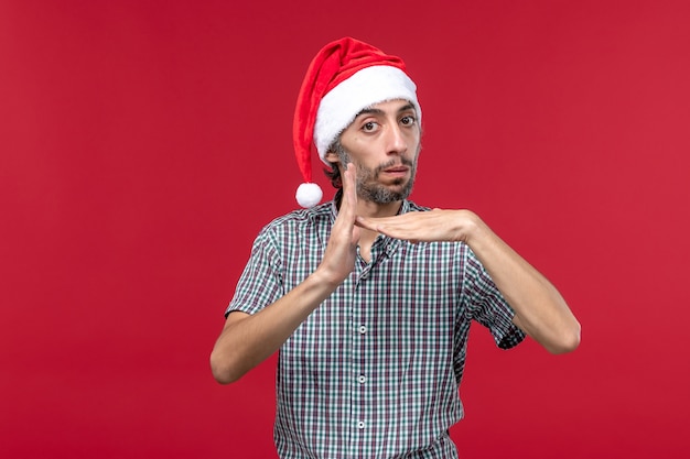 Front view young person with serious expression on red wall holiday new year male red