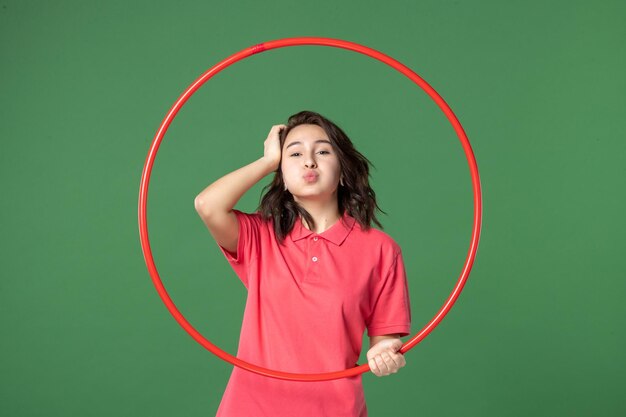 Front view young saleswoman holding red hula hoop on green background yoga body sale uniform shopping athlete work sport