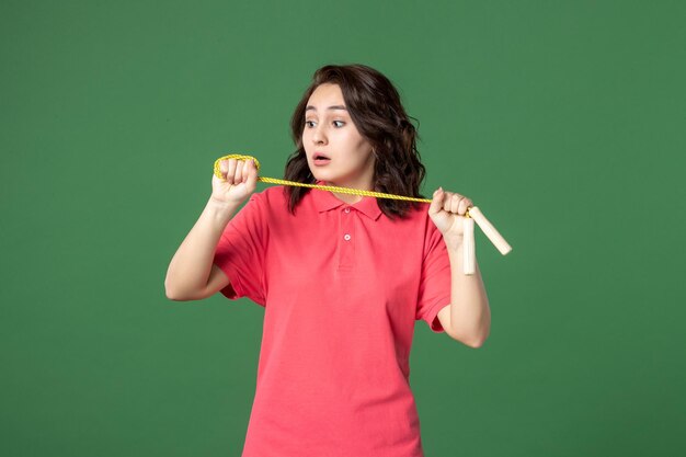 Front view young saleswoman holding skipping rope on green background sale boutique uniform present worker sport health job