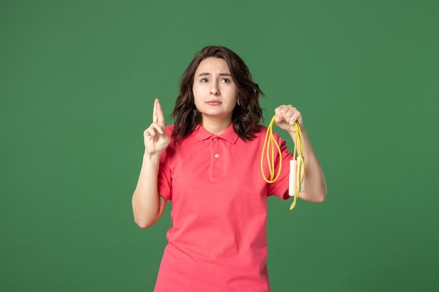 Front view young saleswoman holding skipping rope on green background sale boutique uniform shopping worker health job present