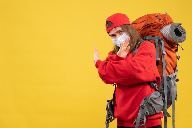 Front view young tourist with tourist backpack and mask crossing hands