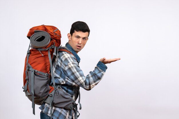 Front view young traveler man with backpack showing something