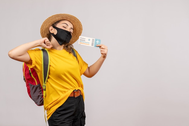 Front view young traveller with backpack holding up ticket streching